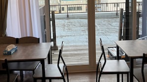 A hotel room with a balcony, wooden flooring, and a table with chairs. - Bigstone Terrace Suite Tsutsumimachi (Aomori)