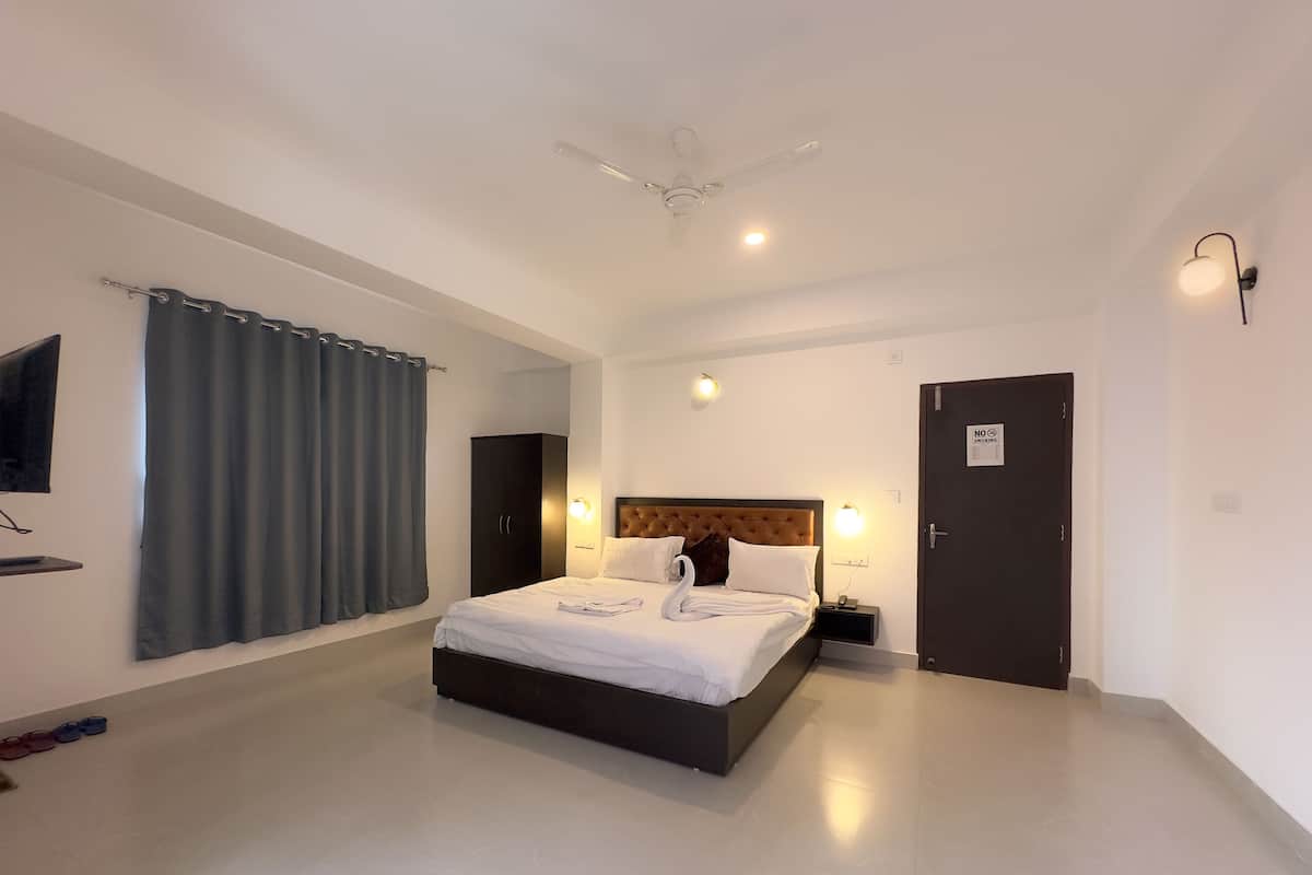 Une chambre d’hôtel avec un lit, un ventilateur de plafond, une télévision et une porte avec une pancarte.
