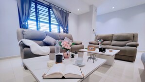 A modern living room with two sofas, a coffee table, and a bookshelf.