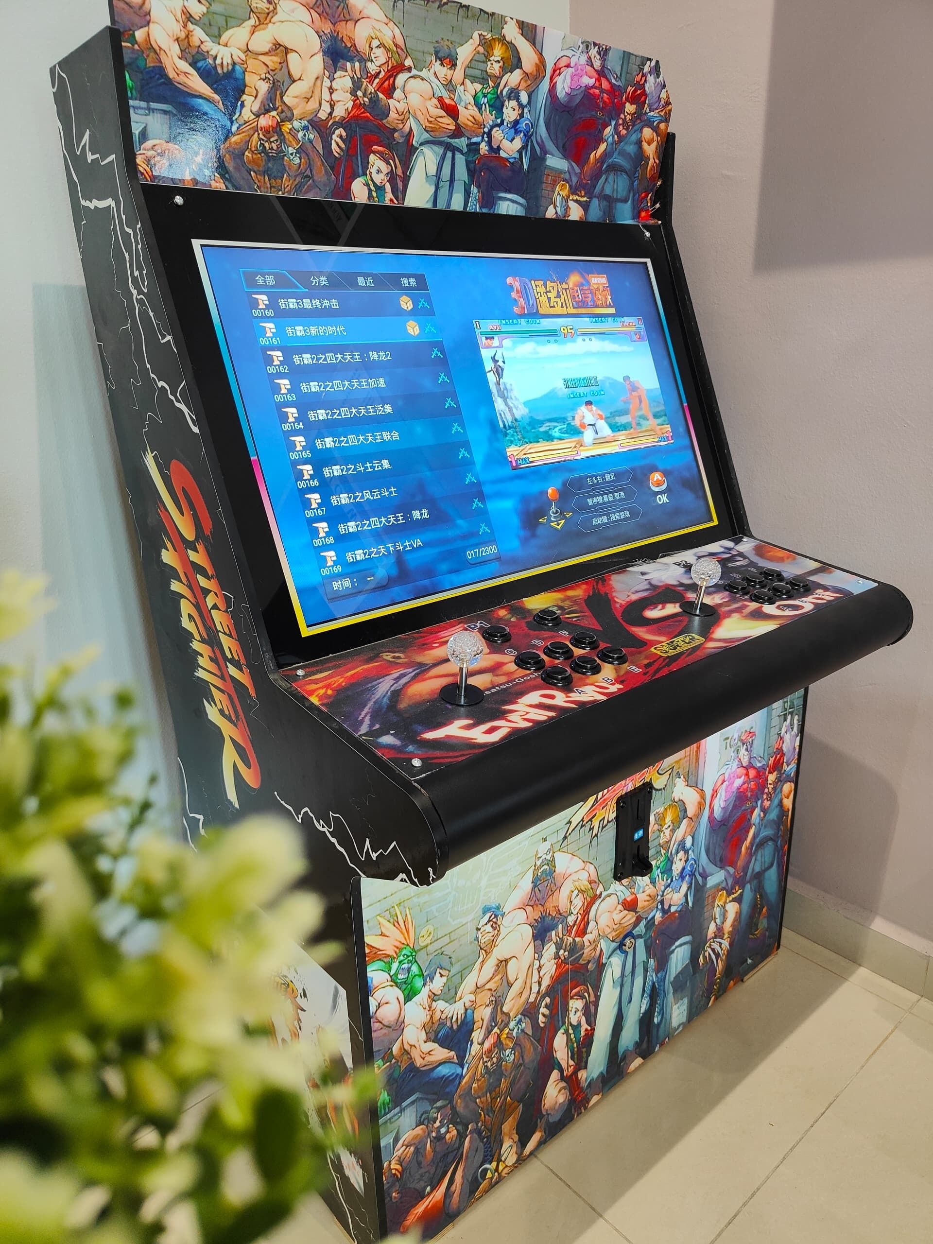 A gaming console with a screen displaying a fighting game, surrounded by artwork of various characters.