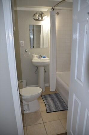 Une salle de bain avec des toilettes, un lavabo et une baignoire.