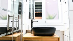 A modern bathroom with a black vessel sink, a glass shower enclosure, and a wooden vanity. - M (RVI40) Cozy one-bedroom apartment in Cuatro Caminos (Madrid)