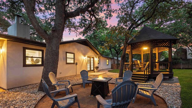 Une terrasse avec des fauteuils Adirondack, un foyer et un belvédère.
