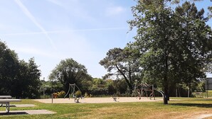 A park with playground equipment, a picnic table, and a dirt path. - 3-bedroom chalet with terrace in green setting (Marzan)