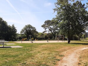 A park with playground equipment, a picnic table, and a dirt path. - 3-bedroom chalet with terrace in green setting (Marzan)