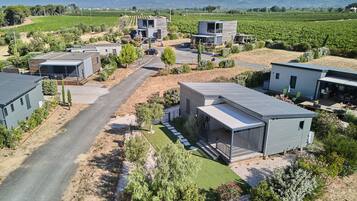Un quartier résidentiel avec des maisons modernes, une allée pavée et un vignoble en arrière-plan.