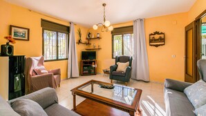 A living room with a sofa, armchairs, a coffee table, a TV, and a chandelier. - Beautiful home in Alcala la Real (Alcala la Real)
