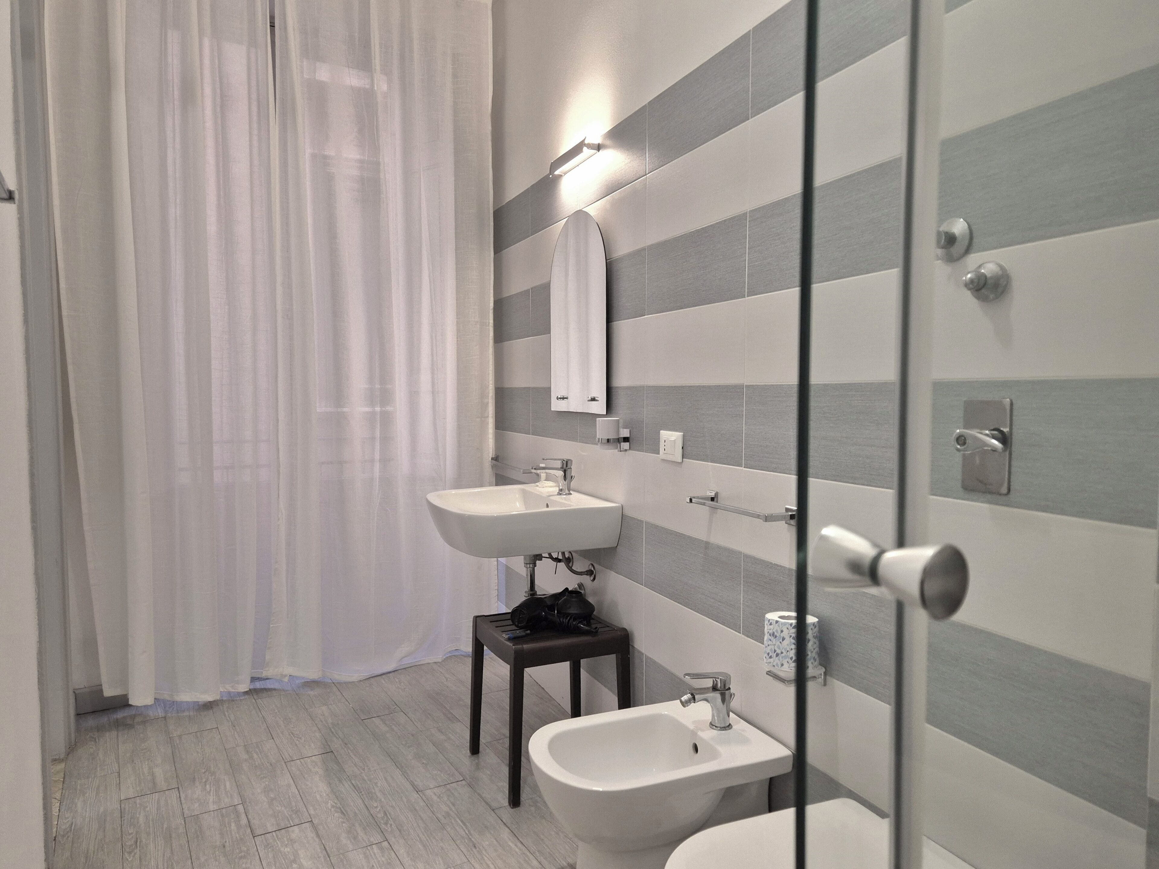 Ein modernes Badezimmer mit Duschkabine aus Glas, zwei Waschbecken und einer Toilette.