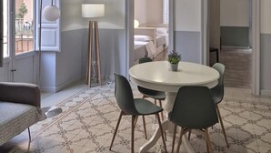 A dining area with a round table, chairs, a hanging light fixture, and a patterned floor. - CASE VACANZE LA MATTANZA (Trapani)