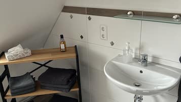 Een douche, handdoeken, zeep, shampoo
