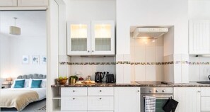 A modern kitchen with white cabinets, a tiled backsplash, and a built-in oven.