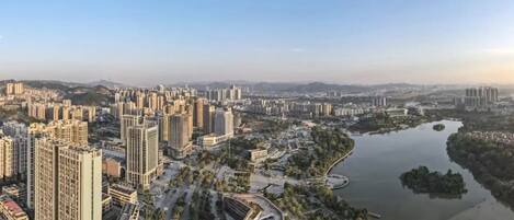A high-rise building complex with a river and park area.
