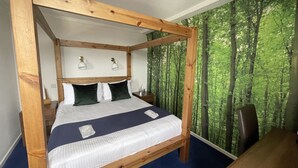 Una cama con dosel, un cabecero, ropa de cama blanca y un detalle en azul.