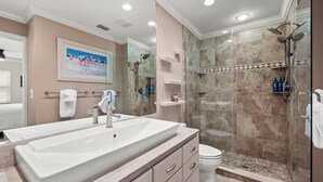 Une salle de bain moderne avec un grand lavabo, une douche à parois de verre et des toilettes.