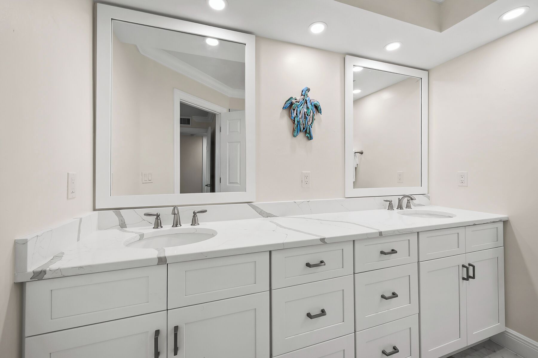 A bathroom with two sinks, a large mirror, and a cabinet with drawers.