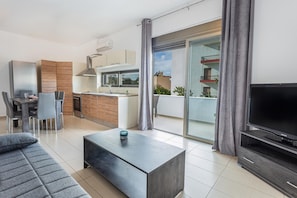 A modern apartment with a dining area, kitchen, living room, and balcony. - Iriana's Apartments in Center (Chania)