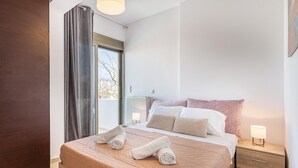 Una camera da letto con un letto grande, un comodino, un termosifone e una finestra con tende.