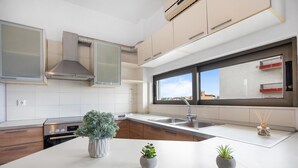 Una cucina moderna con isola centrale, elettrodomestici integrati e una finestra vista città.