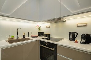 Uma cozinha moderna com forno embutido, cafeteira e chaleira.