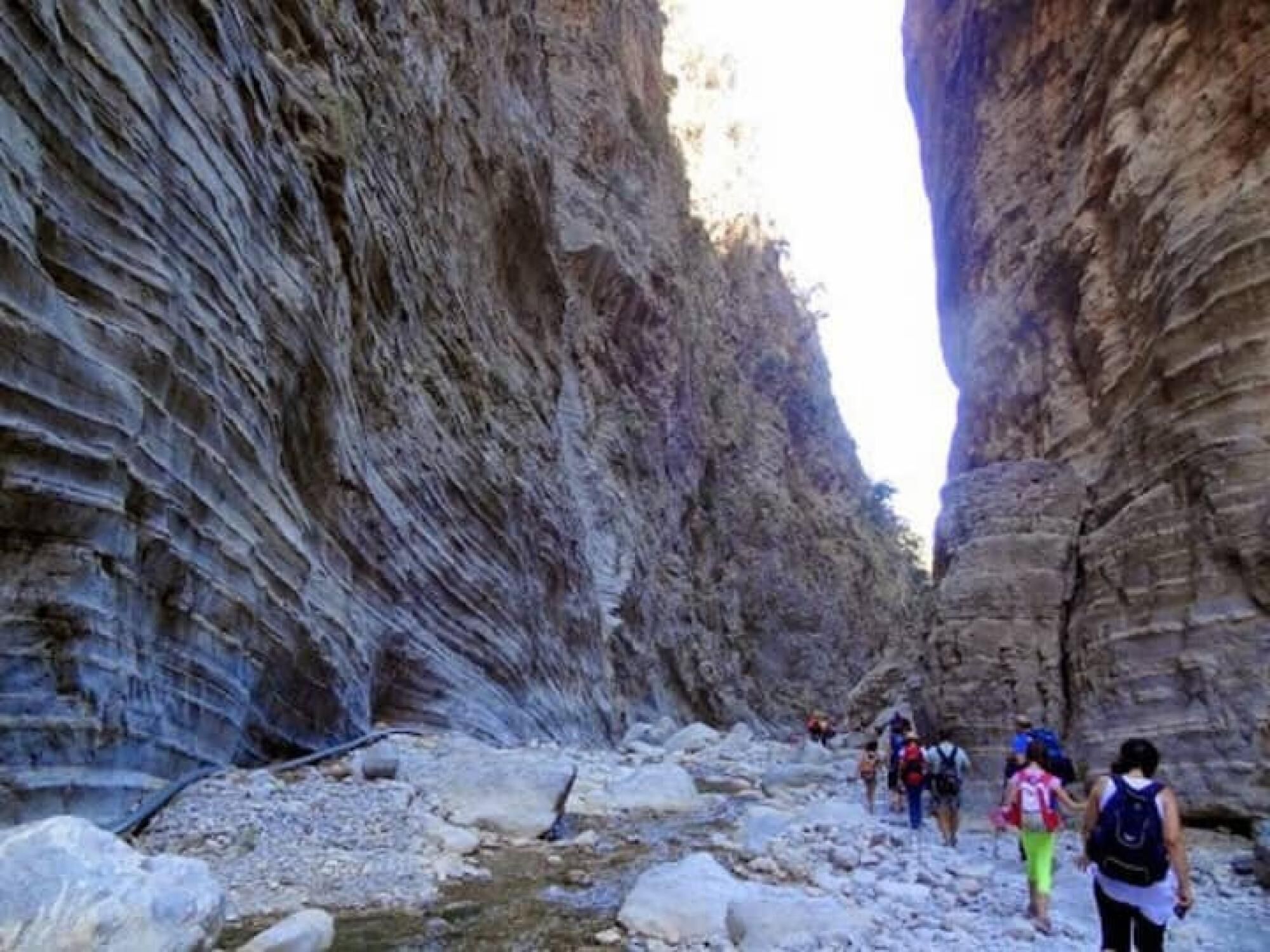 Un estrecho sendero en un cañón con excursionistas.