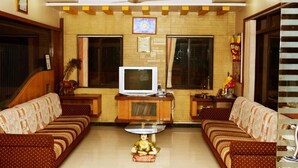 Una sala de estar con dos sofás, televisor y ventilador de techo.