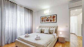 A neatly made bed with a headboard, a bedside lamp, and a folded towel on the nightstand. - Valle Aurelia vatican apartment: Your Charming Retreat bear S.Peter (Roma)