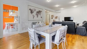 A modern living room with a dining area, a sofa, and a TV. - Valle Aurelia vatican apartment: Your Charming Retreat bear S.Peter (Roma)