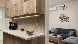 A modern kitchen with wooden cabinetry and a built-in island, a coffee maker, and a fruit bowl. - Harmony Apartment in Chania (Chania)