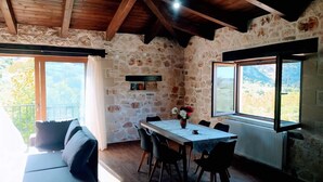 A rustic stone interior with a dining table, chairs, and a sofa. - Traditional Villa in Pemonia (Apokoronas)