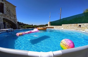 A swimming pool with a stone building and a green wall in the background. - Traditional Villa in Pemonia (Apokoronas)