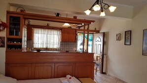 Ein Schlafzimmer mit hölzernem Kopfteil, einem Bett mit weißer Bettwäsche, einer Bank und einem kleinen Tisch.