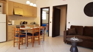A compact living space with a kitchen, dining area, and a sofa. - Ilia s Apt in Chania (Chania)