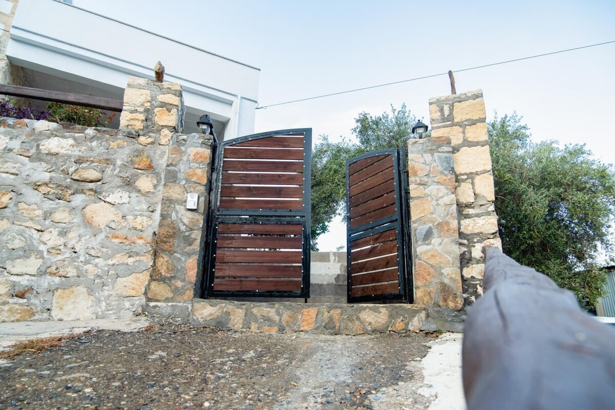 A stone wall with two wooden gates.