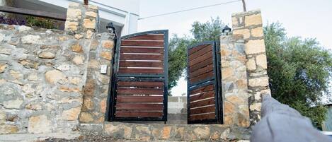A stone wall with two wooden gates.