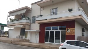 Ein zweistöckiges Gebäude mit roter Fassade und einem weißen Balkon.