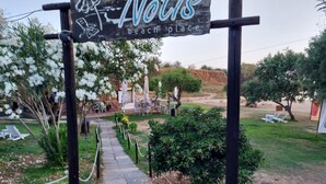 A pathway leading to a beach area with outdoor seating and umbrellas. - Chrissoula House In Agioi Apostoloi (Chania)
