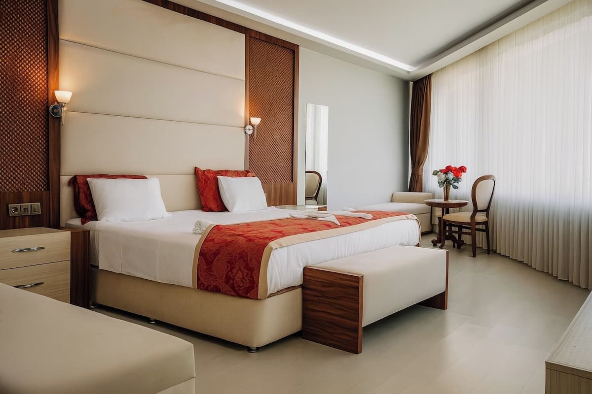 A modern hotel room with a large bed, a desk, and a chair.