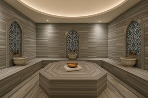A spa room with a central seating area, two side sinks, and decorative tiles on the walls. - Cevaher Hotel & Suites (Yomra)