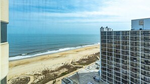 A high-rise hotel overlooking a beach with a clear view of the ocean.