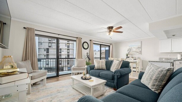 A spacious living room with a large sofa set, a coffee table, and a ceiling fan. - Ocean Princess-Beautiful 2 Bedroom Condo! (Ocean City)
