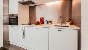 A modern kitchen with stainless steel appliances, a sink, and a countertop with various items. - Studio S. José By Gt House (Lisbon)