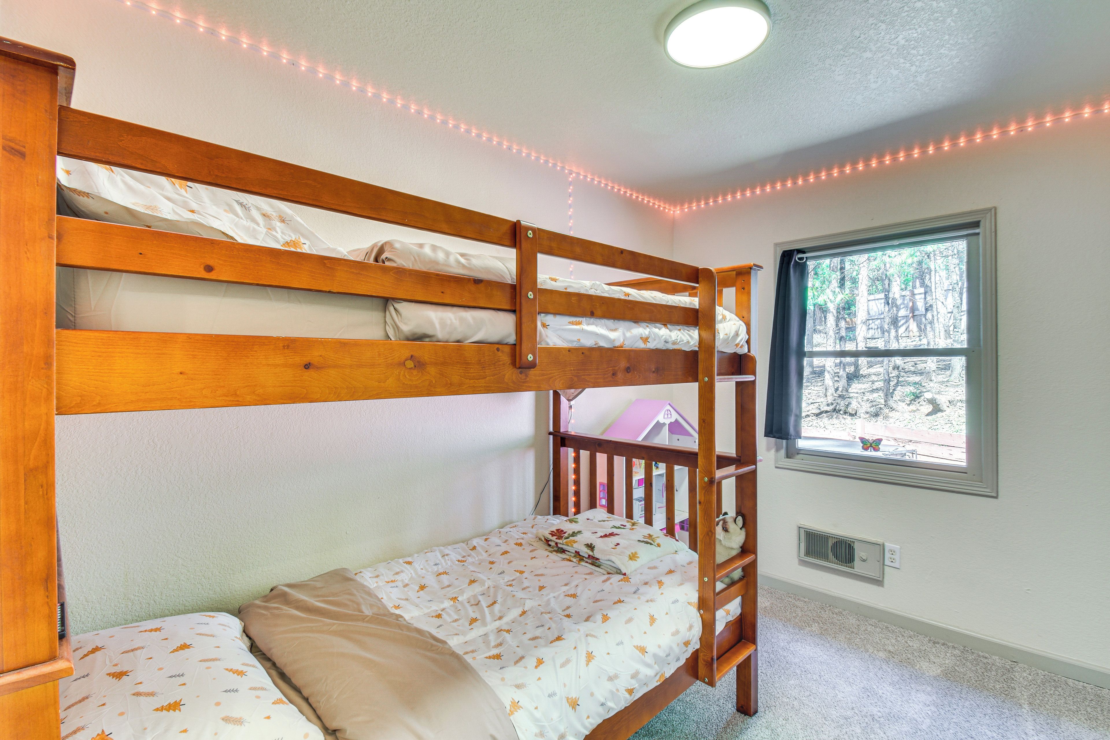 Camera con letto a castello, finestra, ventilatore a soffitto e bocchetta di areazione.