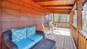 Eine Holzterrasse mit einem Korbsessel und Schaukelstühlen.
