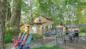 Une cabane en bois dotée d’une terrasse, d’un espace salon extérieur et d’un foyer.