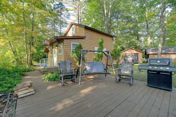 Une terrasse en bois avec un espace salon extérieur et un coin barbecue.
