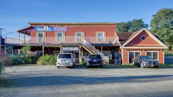 A two-story building with a sign for 'The Doors' and 'Seafood House'. There are two cars parked in front.