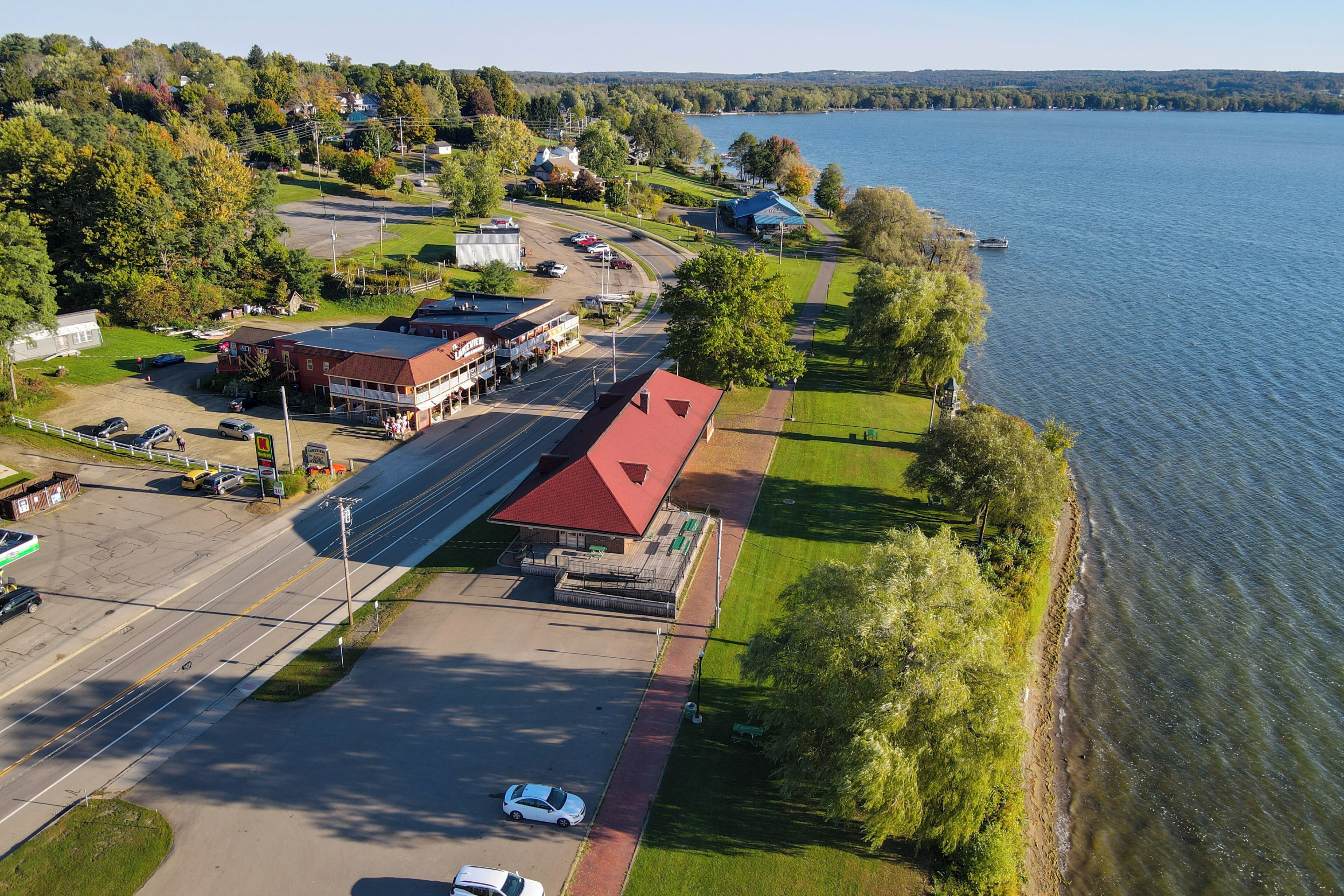 An aerial view of a lakeside property with a main building, parking lot, and a boat dock.
