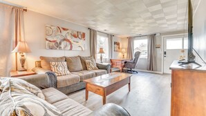 A spacious living room with a sofa, coffee table, and a television. - Family-friendly Ontario Home in Central Location! (Ontario)
