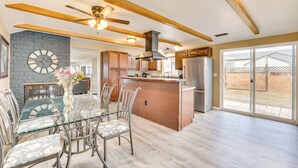 A modern kitchen with wooden beams, a central island, and a dining area with glass-top table and chairs. - Family-friendly Ontario Home in Central Location! (Ontario)