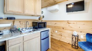 A compact kitchen with wooden cabinets, a microwave, a sink, and a dishwasher. - Near Hiking & Biking: Newport Cabin in the Smokies (Newport)